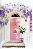 This carefully composed doorway scene in Paddington shows a soft pink front door set against whitewashed walls, its pastel colour radiating a sense of warmth and gentle welcome. Above, thick trails of wisteria hang in cascading layers of lavender, their blossoms forming a fragrant curtain that recalls the blooming façades around Hyde Park's edges and the residential streets near Lancaster Gate. The wisteria frames the doorway with a delicate, flowing outline, and the light filtering through its petals casts soft, mottled shadows across the door and the stone step. At the threshold sits a grey metal bucket filled with a generous arrangement of white and cream roses, their full, velvety blooms pressed close together in a lush cluster. Sprigs of fresh green foliage push through the roses, offering contrast and texture, while a pale pink ribbon is tied around the bucket's base, its satin loops and trailing ends echoing the tone of the door and adding a romantic finishing touch. The whole image evokes the feeling of a housewarming gift or a congratulatory gesture for someone stepping into a new home not far from Paddington Station or the leafy paths of Hyde Park. Although still, the scene feels alive with quiet anticipation, as though the scent of the roses and wisteria is already filling the hallway inside. Every detail-from the pastel colour palette and the gentle light to the carefully arranged florals-creates an atmosphere of comfort, optimism, and the soft thrill of beginning a fresh chapter in a much-loved corner of London.